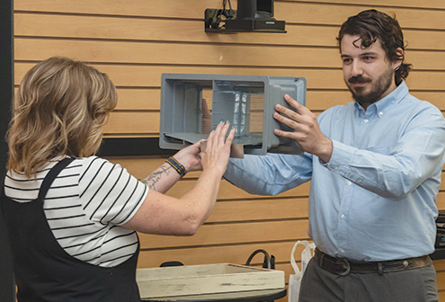 Melanie McClure and Nile Walter of Team Fire Stoppers, demonstrate their ember arrester screen that prevents embers and ash from entering a home during a wildfire.